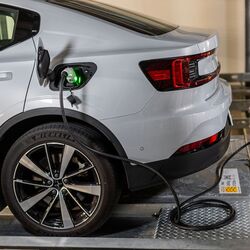 The car is charged with electricity and is positioned on a platform within the parking system.