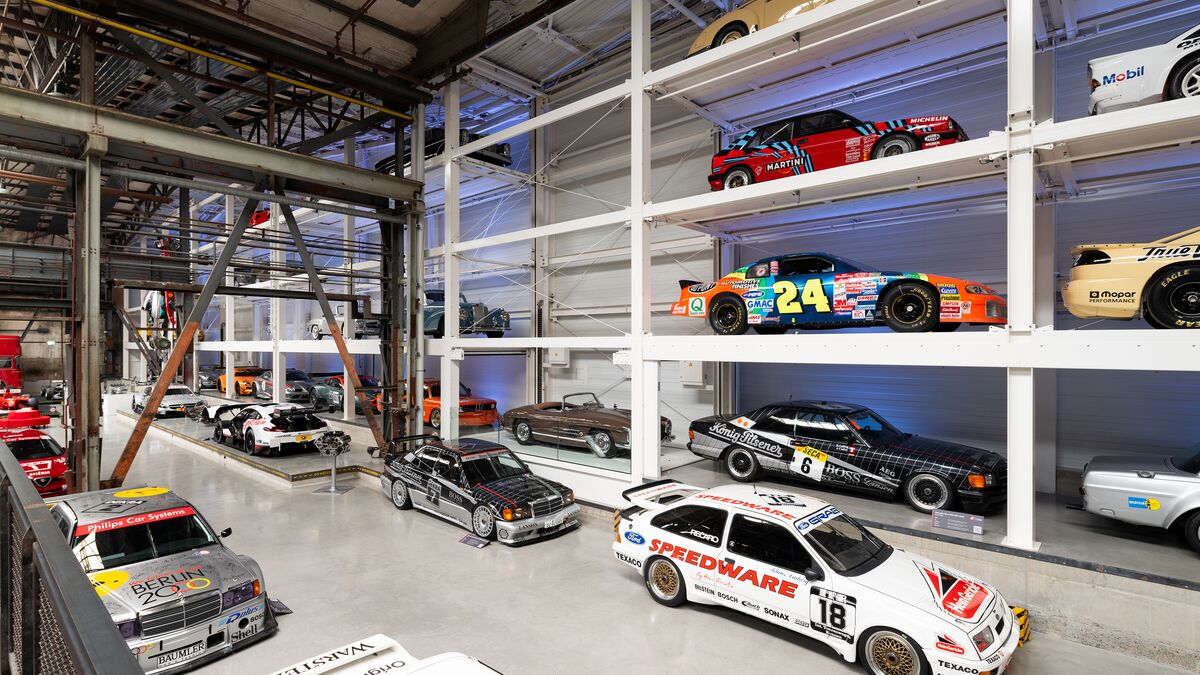 A wall-mounted shelf full of cars in a museum