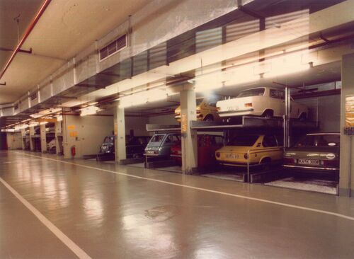 Photo d'un parking souterrain où les voitures sont empilées les unes sur les autres dans un système de stationnement