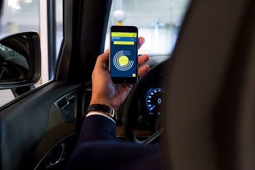 Une personne tient son téléphone portable à la main, l'application ouverte
