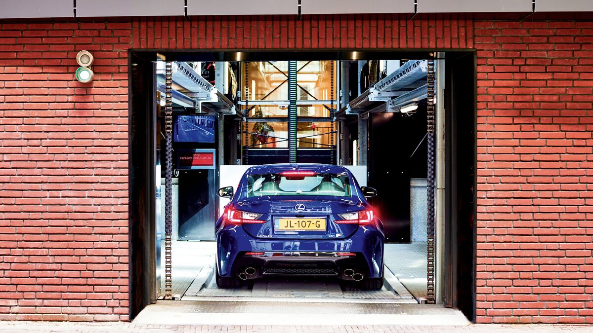 Mur de maison avec une porte de garage ouverte dans laquelle une voiture s'engage