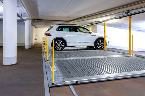 Plate-forme de stationnement avec une voiture garée dessus dans un parking souterrain