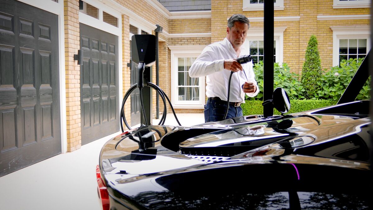 Un homme branche le chargeur sur sa voiture