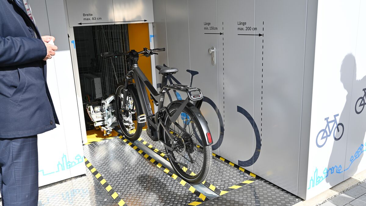 Vélo sur un rail devant un système de stationnement automatique pour vélos
