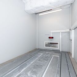 The image shows the empty transfer area of an automated parking system, where vehicles are positioned before being automatically stored.