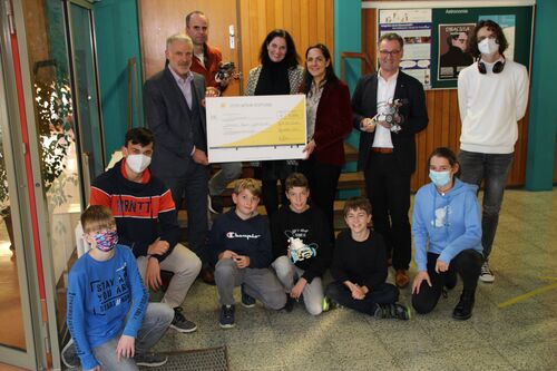 Group photo showing several people holding up a cheque