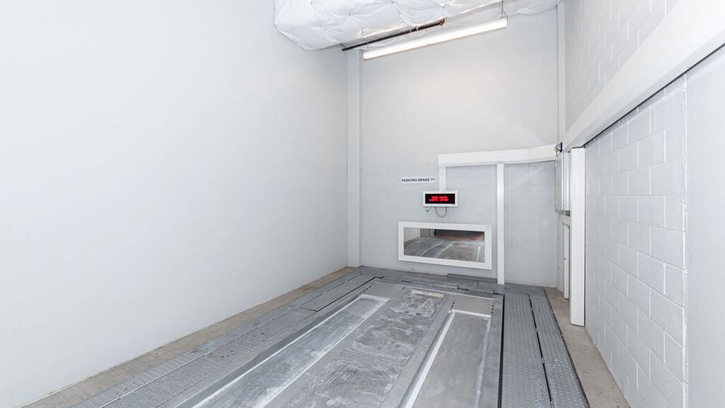 The image shows the empty transfer area of an automated parking system, where vehicles are positioned before being automatically stored.