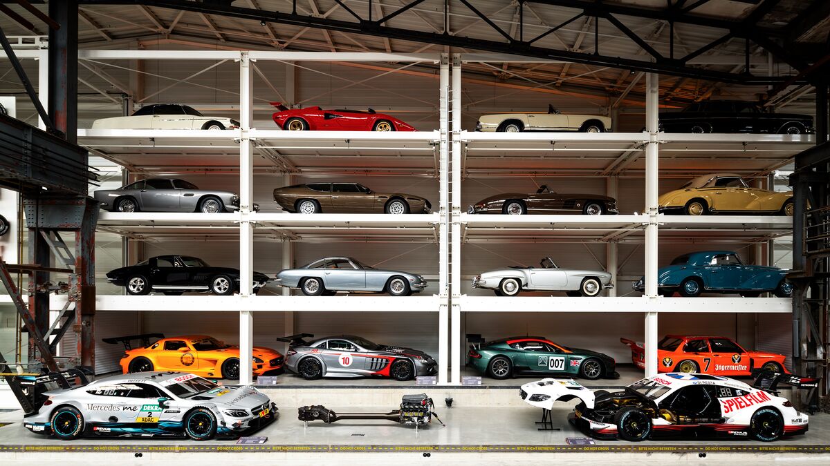 A wall-mounted shelf full of cars in a museum