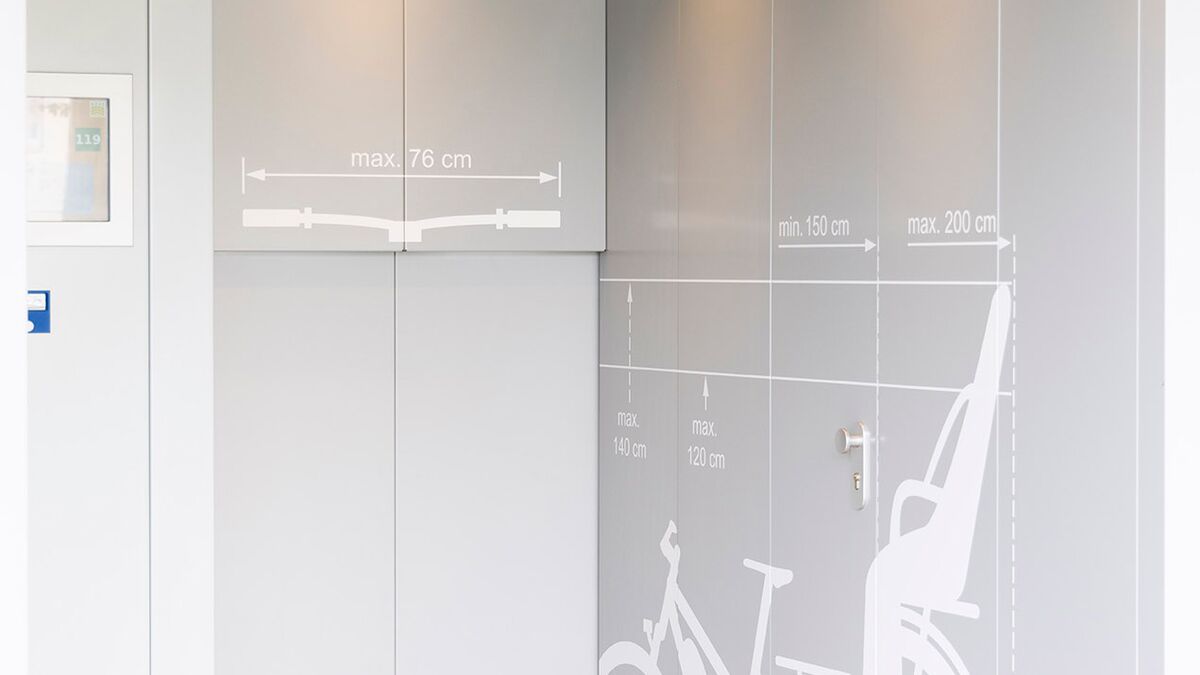 Zone d'entrée d'un parking à vélos en hauteur avec un pictogramme représentant un vélo sur le mur