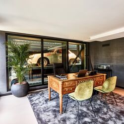 Bureau avec table et chaises, avec une voiture garée en arrière-plan