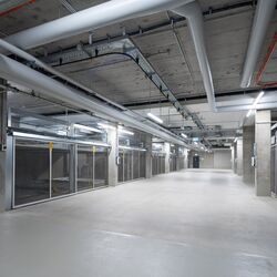 Vue de l'allée dans le parking souterrain entre les systèmes de stationnement latéraux