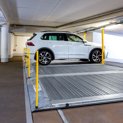 Plate-forme de stationnement avec une voiture garée dessus dans un parking souterrain