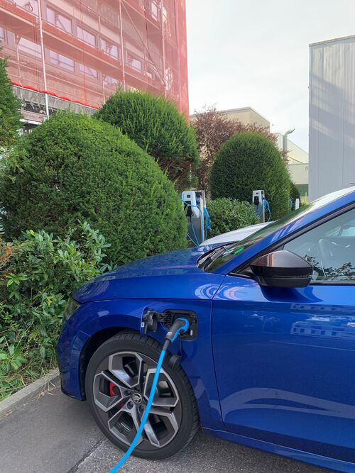 A blue car is being charged at an electric charging station