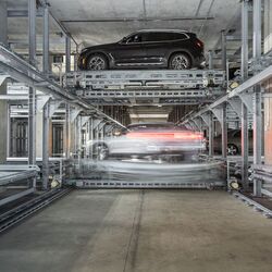 La voiture est garée sur une plateforme de stationnement dans un système de parking automatisé.