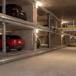 La voiture est garée sur une palette de stationnement dans un système de parking à étagères